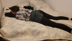 Mince brune en leggings noirs s&rsquo;allonge sur le ventre