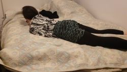 Jeune brune en collants explore le lit à quatre pattes